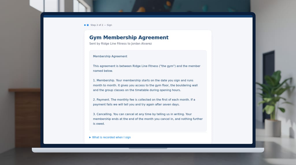 A laptop at a climbing gym's front desk, close up, showing the SignSealer signing page for a gym membership agreement sent by Ridge Line Fitness, with the agreement's text in full.